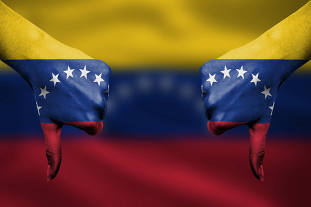 failure of Venezuela - hands gesturing thumbs down in front of flagの写真素材