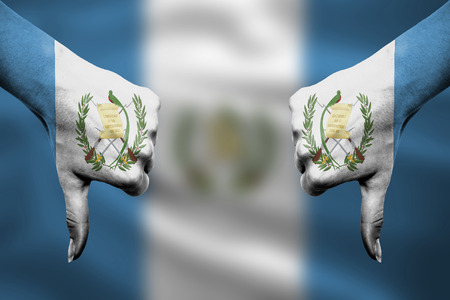 failure of Guatemala - hands gesturing thumbs down in front of flagの写真素材