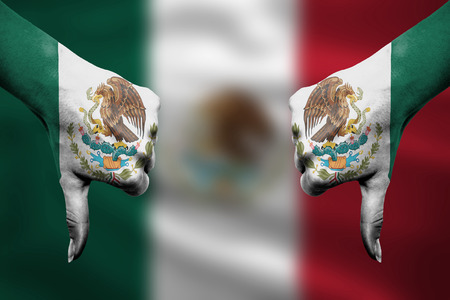 failure of Mexico - hands gesturing thumbs down in front of flagの写真素材