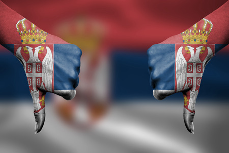failure of Serbia - hands gesturing thumbs down in front of flagの写真素材
