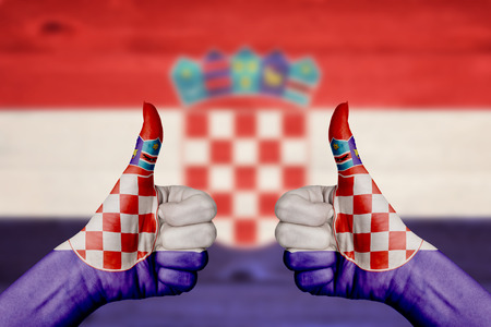 Croatia flag painted on female hands thumbs up with blurry wooden backgroundの写真素材