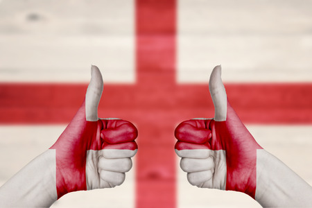 Georgia flag painted on female hands thumbs up with blurry wooden backgroundの写真素材