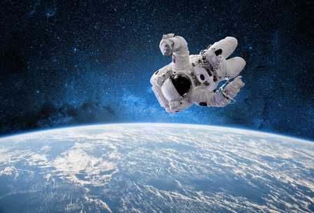 Astronaut in outer space with planet earth as backdrop. Elements of this image furnished by .
