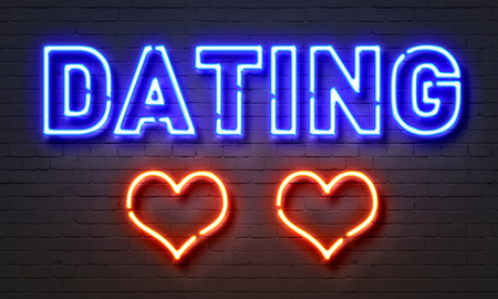 Dating neon sign on brick wall backgroundの写真素材