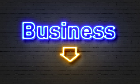 Business neon sign on brick wall backgroundの写真素材