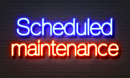 Scheduled maintenance neon sign on brick wall backgroundの写真素材