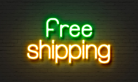 Free shipping neon sign on brick wall backgroundの写真素材
