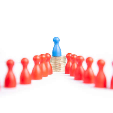 The concept of wage or pay gap: discrimination between men and women. Blue pawn representing men on top of coins.の写真素材