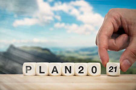 Hand bringing dice to make the expression plan 2021.
