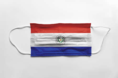 Face mask with Paraguay flag printed, on white background, isolated. Covid-19 concept.の写真素材