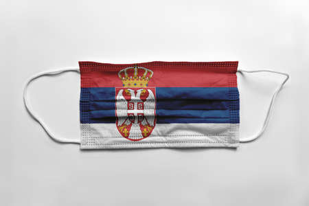 Face mask with Serbia flag printed, on white background, isolated. Covid-19 concept.の写真素材