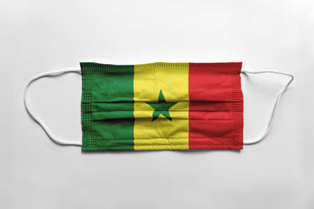 Face mask with Senegal flag printed, on white background, isolated. Covid-19 concept.の写真素材