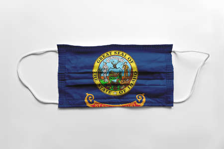 Face mask with Idaho flag printed, on white background, isolated safety conceptの写真素材