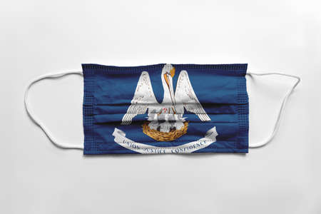 Face mask with Louisiana flag printed, on white background, isolated safety conceptの写真素材