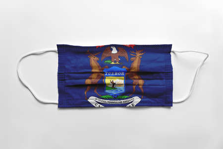 Face mask with Michigan flag printed, on white background, isolated safety conceptの写真素材