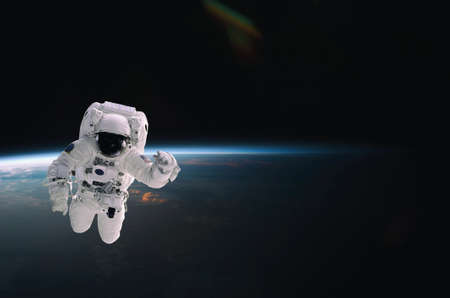 Astronaut walking in space with earth background, with flare.の写真素材