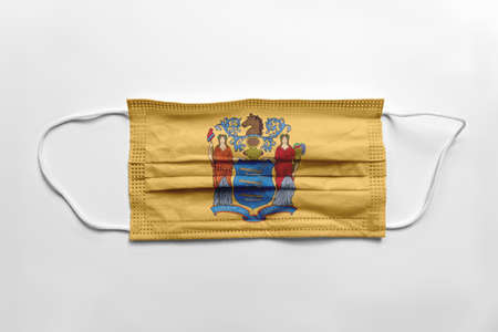 Face mask with New Jersey flag printed, on white background, isolated safety conceptの写真素材