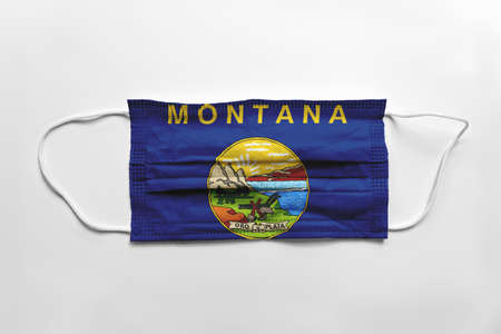 Face mask with Montana flag printed, on white background, isolated safety conceptの写真素材