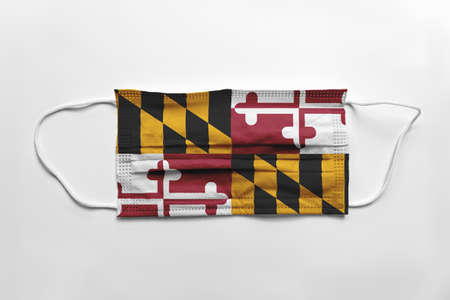 Face mask with Maryland flag printed, on white background, isolated safety conceptの写真素材