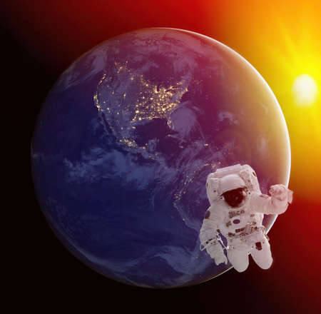 Astronaut walking in space with earth at night background.の写真素材