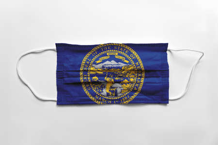 Face mask with Nebraska flag printed, on white background, isolated safety conceptの写真素材