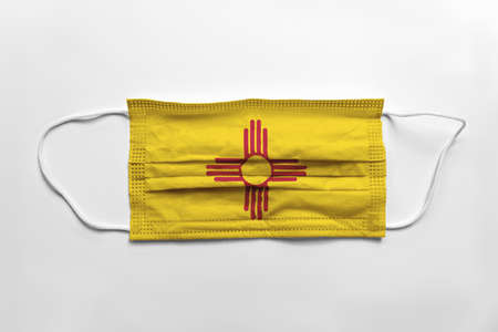 Face mask with New Mexico flag printed, on white background, isolated safety conceptの写真素材