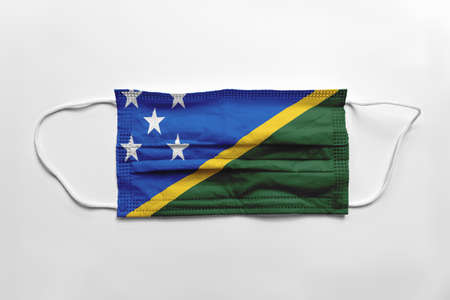 Face mask with the Solomon Islands flag printed, on white background, isolated.の写真素材