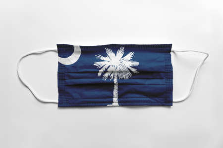 Face mask with South Carolina flag printed, on white background, isolated safety conceptの写真素材