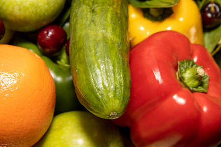 A group of fruit and vegetables including a large cucumber and red pepperの写真素材