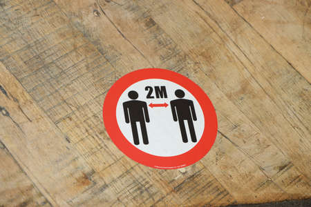 A sign on the floor to guide people to keep 2 metres apart and to follow social distancing rules on...
