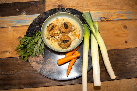 A delicious Chicken Cobbler with dumplings on a wooden kitchen work top surrounded by vegetablesの写真素材