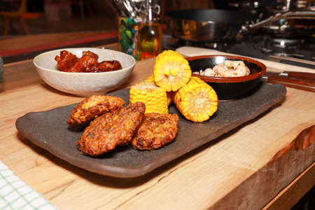 A delicious meal of prawns sweetcorn and onion bhajis on a wooden worktopの写真素材