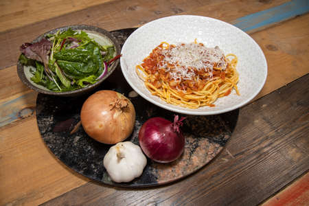 A plate of delicious tuna pasta spaghetti bolognese topped with grated cheeseの写真素材