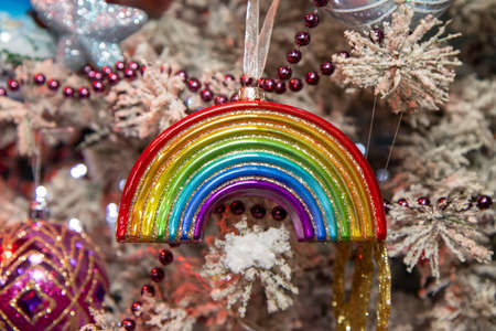 A Christmas ornament in the Shape of a rainbow on a festive Christmas treeの写真素材