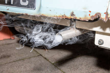 A smoking exhaust tail pipe from an old rusty carの写真素材
