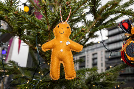 A home made Christmas decoration hanging from a Christmas tree in the shape of a a little doll
