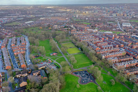 Aerial photo of the village of Beeston in Leeds West Yorkshire showing a typical British park along side rows of terrace houses, roads and streets, taken in the winter time on a wet cold day.の写真素材