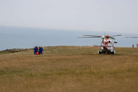 East Sussex, Beachy Head, UK 10th July 2019: The HM Coastguard Rescue team carrying a dead body in a body bag on the cliff top of one of the most common suicide spots in the world.のeditorial素材