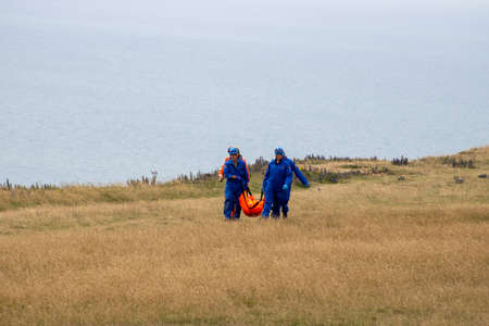 East Sussex, Beachy Head, UK 10th July 2019: The HM Coastguard Rescue team carrying a dead body in a body bag on the cliff top of one of the most common suicide spots in the world.のeditorial素材