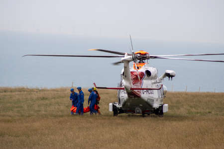 East Sussex, Beachy Head, UK 10th July 2019: The HM Coastguard Rescue team carrying a dead body in a body bag on the cliff top of one of the most common suicide spots in the world.のeditorial素材