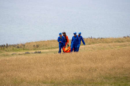 East Sussex, Beachy Head, UK 10th July 2019: The HM Coastguard Rescue team carrying a dead body in a...