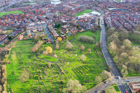 Aerial photo of the village of Beeston in Leeds West Yorkshire showing a typical British park along side rows of terrace houses, roads and streets, taken in the winter time on a wet cold day.の写真素材