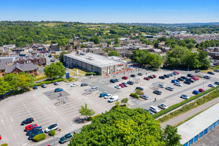 Aerial photo of people in the UK queuing following social distancing rules due to coronavirus at a Tesco supermarket in the village of Cleckheaton, West Yorkshireのeditorial素材