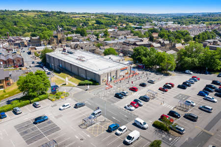 Aerial photo of people in the UK queuing following social distancing rules due to coronavirus at a Tesco supermarket in the village of Cleckheaton, West Yorkshireのeditorial素材