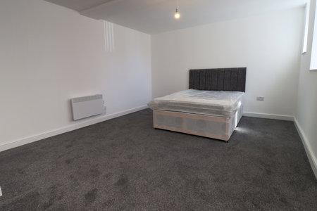 A newly decorated typical British UK bedroom with a large bed, with white walls, grey carpetの写真素材