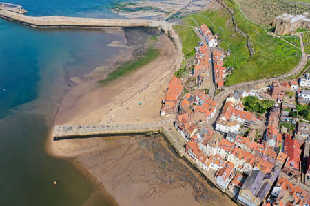 Aerial photo of the beautiful town of Whitby in the UK, North Yorkshire in the UK showing the historic houses and church along side the oceanの写真素材
