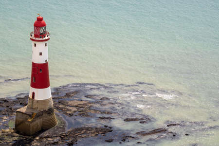 The famous Beachy Head lighthouse located on the rocky beach of Beachy Head the chalk headland cliff in East Sussex showing a typical British light houseのeditorial素材