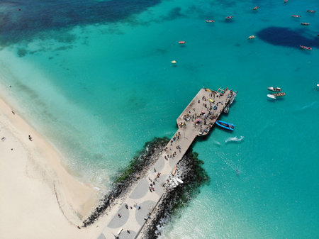 Aerial photo of the beautiful pier and beach at Cape Verde showing fishing boats, and people on the beach taken on a beautiful sunny day.のeditorial素材