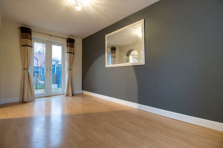 A brand new modern British home showing the dining room with newly fitted wooden floors looking out to the gardenの写真素材
