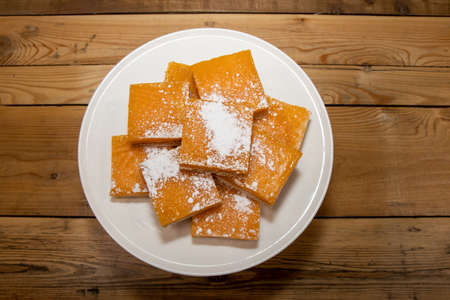 A pile of delicious lemon squares, home made tasty treats on a wooden kitchen tableの写真素材